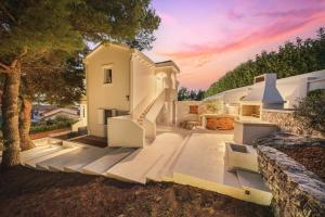 a white house with stairs and a tree at Villa Pearl in Tribunj