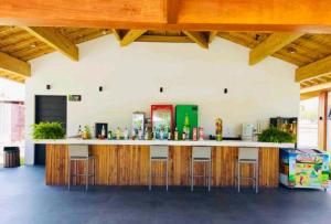 a bar in a building with stools at a counter at Vila do Lago, Praia do Forte in Mata de Sao Joao