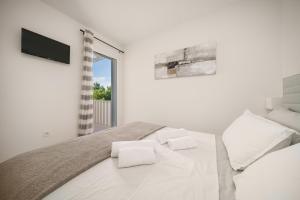 a white bedroom with a large bed with white pillows at Villa Pearl in Tribunj +48 photos