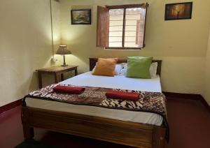 1 dormitorio con 1 cama con 2 almohadas en The Wind Chime - SUPRAD Estate en Suntikoppa