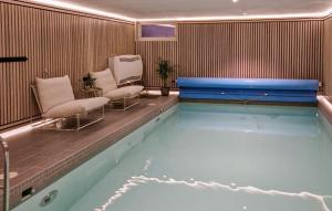 una piscina con 2 sillas y una bañera en Awesome Home In Koppang With Indoor Swimming Pool, en Koppang