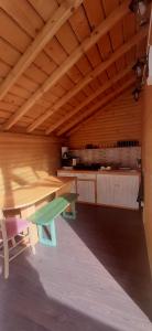 Habitación con techos de madera, mesa y bancos. en Luna de miere en Cinciş