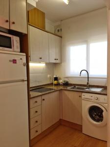 uma cozinha com um frigorífico branco e uma máquina de lavar louça em Arenas doradas em Arenales del Sol