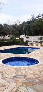 a swimming pool with blue water in a patio at Sitio Terra Azul in Guarulhos