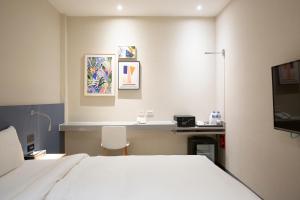 a bedroom with a white bed and a desk and a desk at Cityinn Hotel Taipei Station Branch I in Taipei