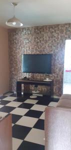 uma sala de estar com uma televisão de ecrã plano numa parede de tijolos em Sitio Terra Azul em Guarulhos