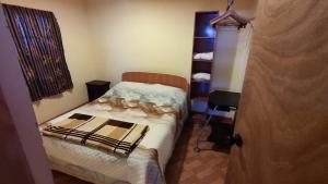 een kleine slaapkamer met een bed en een stoel bij Cabañas Flor de Higuera in San Pedro de Atacama