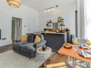 un soggiorno con divano e tavolo di Beach Apartment a Hastings