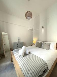 een slaapkamer met een groot bed met witte lakens bij Beach Apartment in Hastings