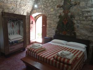 a bedroom with a bed in a stone wall at Agriturismo Castello Di Belforte in Todi