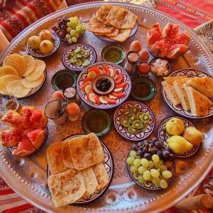 a table with a bunch of different types of food at Merzouga Nice luxury Camp in Merzouga