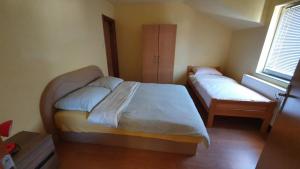 - une petite chambre avec 2 lits et une fenêtre dans l'établissement Apartmani Šćit, 