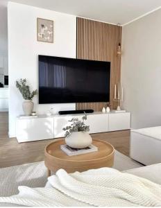 sala de estar con TV y mesa de centro en Apartments White Sky 26 Hanza Tower POOL JACUZZI SAUNA, en Szczecin