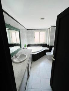 La salle de bains est pourvue d'une baignoire, d'un lavabo et de toilettes. dans l'établissement Résidence mh, à Casablanca