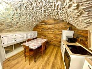 a kitchen with a table and a stone wall at La Mizoùn de Marguerito - Appartamento Ginestra in Acceglio