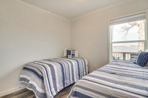 two beds in a room with a window at Pet-Friendly Jay Home with Deck and Grand Lake Views! in Jay
