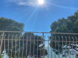 uma vista a partir de uma varanda com uma cerca e árvores em Apartment mit Meerblick am Strand Costa Azzura em Grado