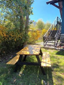 una mesa de picnic sentada en el césped junto a una escalera en Blue House 5 Villa La Angostura en Villa La Angostura