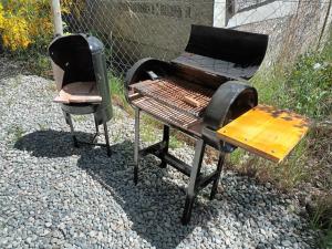 a barbecue grill and a chair sitting on a gravel ground at Blue House 5 Villa La Angostura in Villa La Angostura