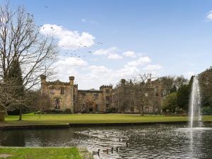 an old castle with a pond and a fountain at The Shieling in Padiham