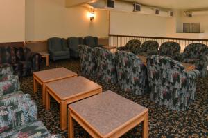 a waiting room with couches and tables and chairs at Canadas Best Value Inn Valemount in Valemount