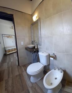 La salle de bains est pourvue de toilettes blanches et d'un lavabo. dans l'établissement Departamento con piscina en Vistalba, à Vistalba