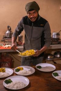 mężczyzna w kuchni trzymający talerz jedzenia w obiekcie Sunsetview Bardia w mieście Bardia