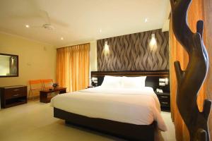 a hotel room with a bed with white sheets and pillows at Splendid Holiday Guest House in Negombo