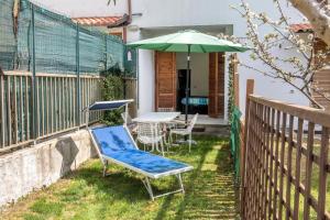 a patio with a table and a green umbrella at Bilocale con portico a Numana - N175 in Numana +8 photos