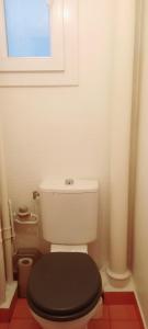 uma casa de banho com um WC com uma tampa preta em 1 Chambre Arena - La Chapelle em Paris
