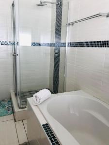 a bathroom with a bath tub and a shower at Dwengu Guest house in Margate