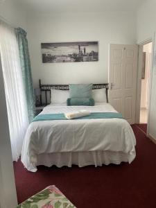 una camera da letto con un grande letto con lenzuola bianche di Dwengu Guest house a Margate
