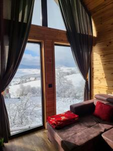 um quarto com um sofá e uma grande janela em LUX PINE house em Zlatibor