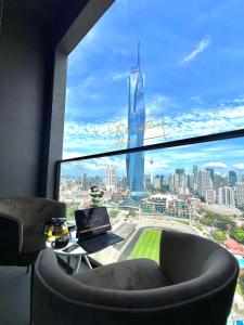 a room with a laptop on a table in front of a window at EUcation Home - Opus Residence in Kuala Lumpur
