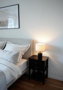 una lámpara en una mesita de noche junto a una cama en Elegantes & Modernes Messe Apartment, Hannover, Laatzen, en Hannover