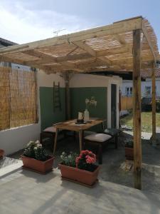uma pérgola de madeira com uma mesa e algumas plantas em Casa Relax Con Giardino Tra Carso e Adriatico em Monfalcone