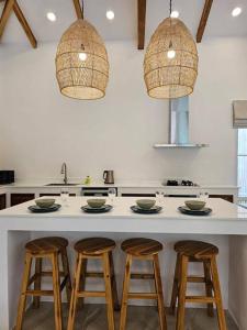 una cocina con una barra con 4 taburetes en SIX Luxury Villa en Ko Phangan