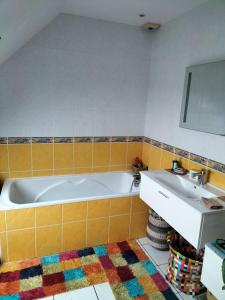 uma casa de banho com uma banheira e um lavatório em Sous le pommier em Douvres-la-Délivrande