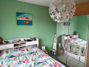 a bedroom with a bed and a large chandelier at Sous le pommier in Douvres-la-Délivrande