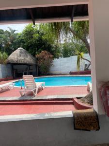a swimming pool with a chair and a chair istg at Dwengu Guest house in Margate