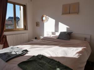 um quarto com uma grande cama branca e uma janela em Casa Relax Con Giardino Tra Carso e Adriatico em Monfalcone