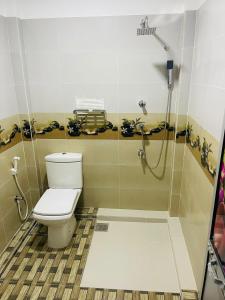 y baño con aseo y ducha. en Villa Arshu., en Bentota