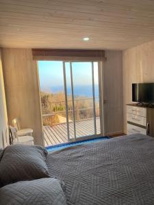 a bedroom with a bed and a large window at Mar&cielo in Zapallar