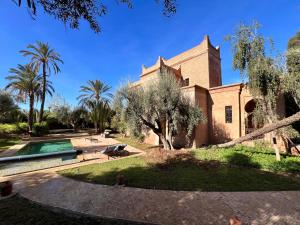 - une vue extérieure sur une maison avec une piscine et des arbres dans l'établissement Villa de luxe Kasbah Amazigh, à Marrakech