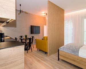 a kitchen and a bedroom with a bed and a table at MTP/ZOO Prestige Apartments in Poznań