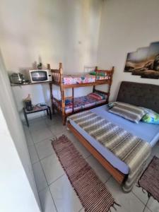 sypialnia z 2 łóżkami piętrowymi i kuchenką mikrofalową w obiekcie Pousada_tres_amores w mieście Itariri