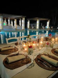 una mesa con velas y sillas junto a una piscina en Borgo Rosso Terra en Gallipoli