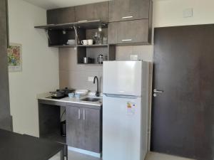 uma cozinha com um frigorífico branco e um lavatório em Elegancia y Confort G&A Rent (308) em Ezeiza