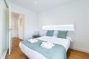 a bedroom with a bed with two white flowers on it at Apartamento Neptuno in Granada