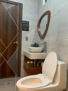 y baño con aseo, lavabo y espejo. en Hotel Sacha Golden, en Otavalo